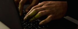 A close-up view of hands typing on a laptop keyboard in a dimly lit environment. Photo by Sora Shimazaki on Pexels.